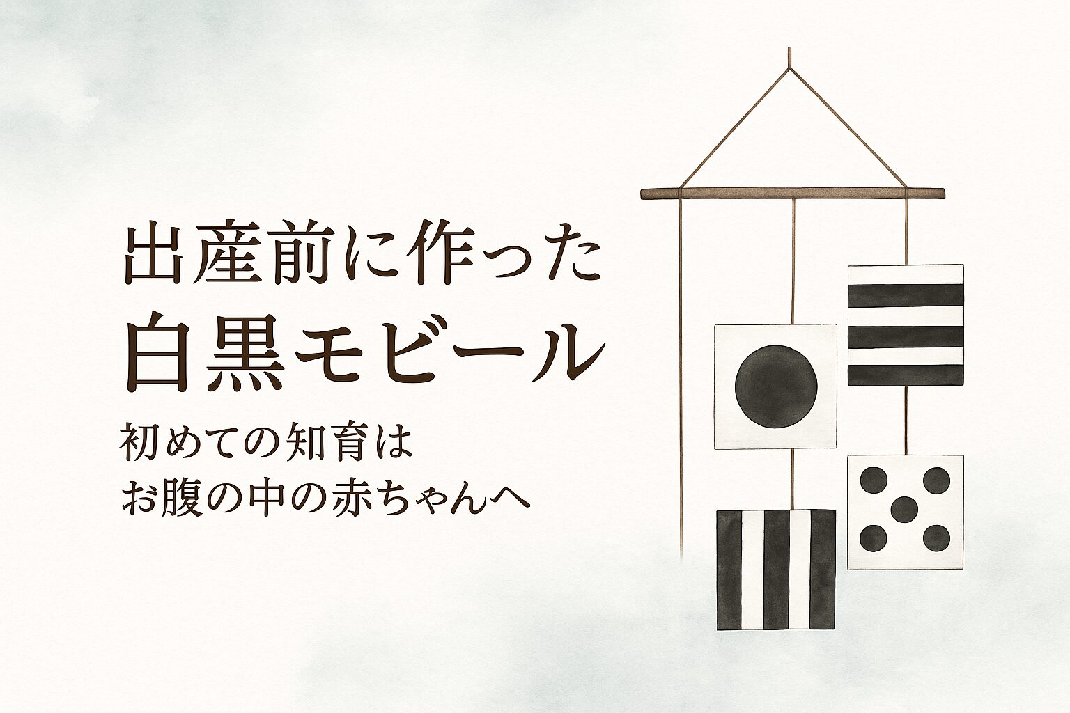 手作りの白黒モビールが木の棒に吊るされている。すべて正方形の紙に水玉や縞模様などの高コントラスト模様が描かれている。